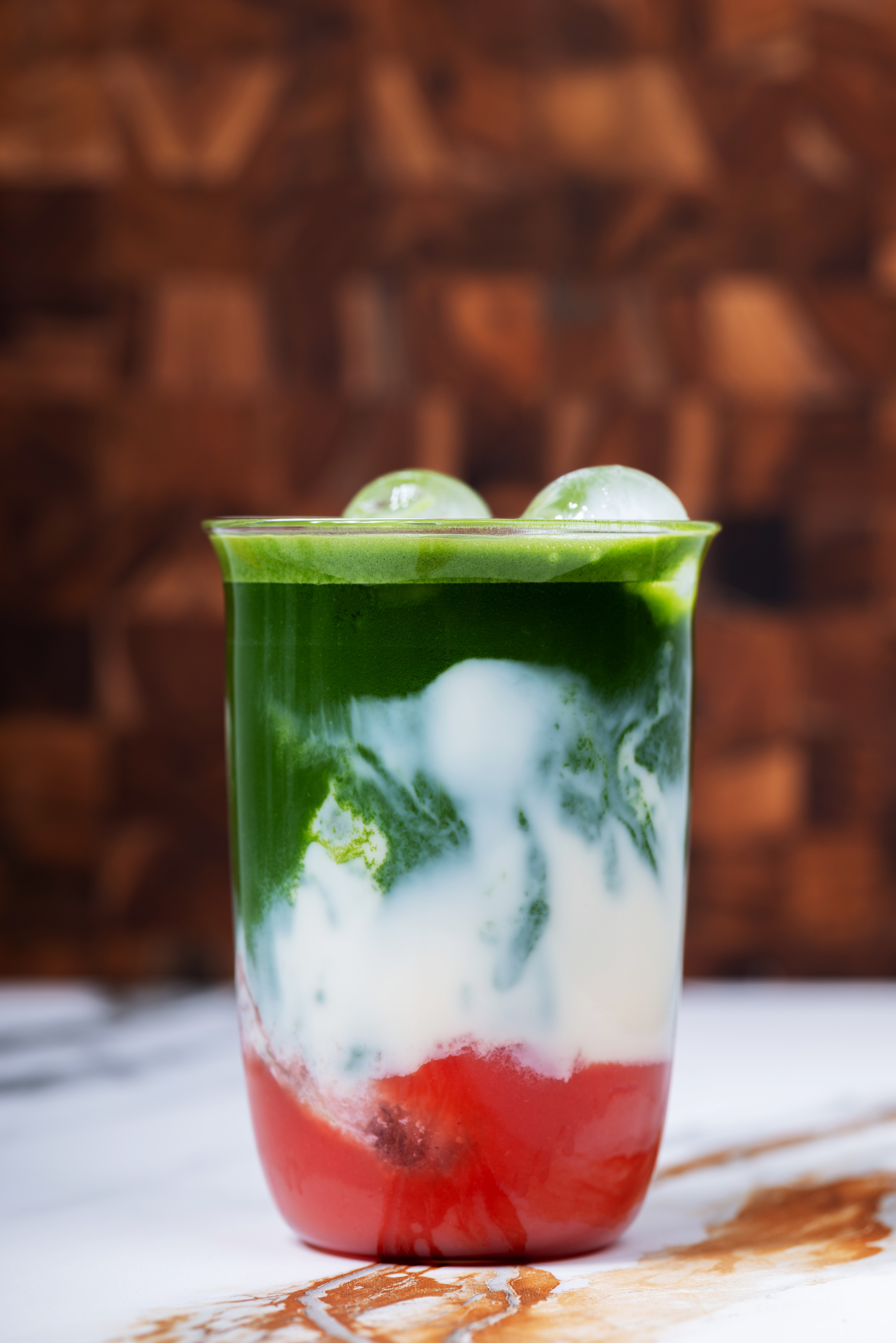 Geschichteter Kinari Matcha Latte mit Eis und roter Fruchtbasis